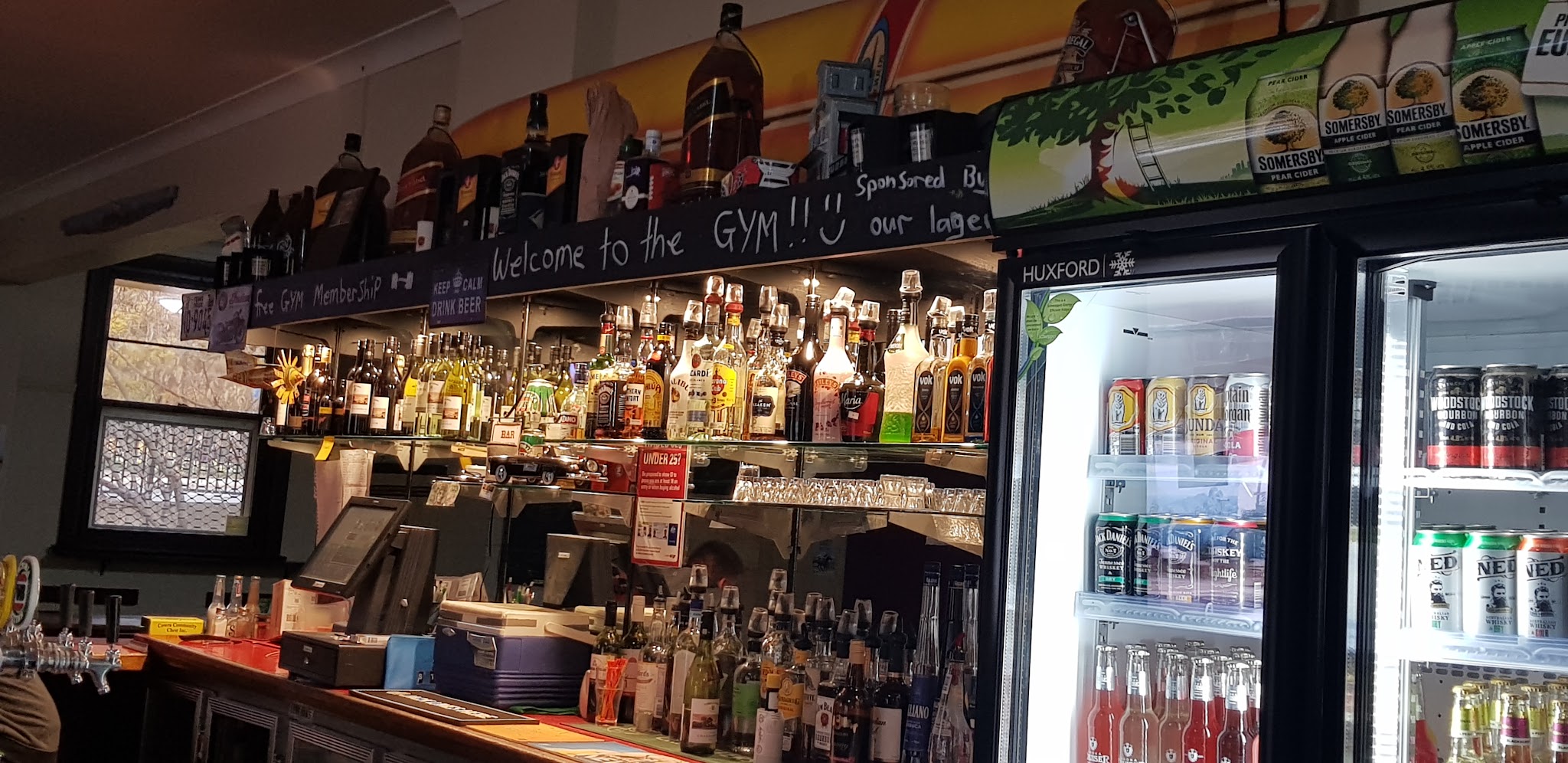 The back bar at the Cowra Hotel lined with bottles and a chalkboard